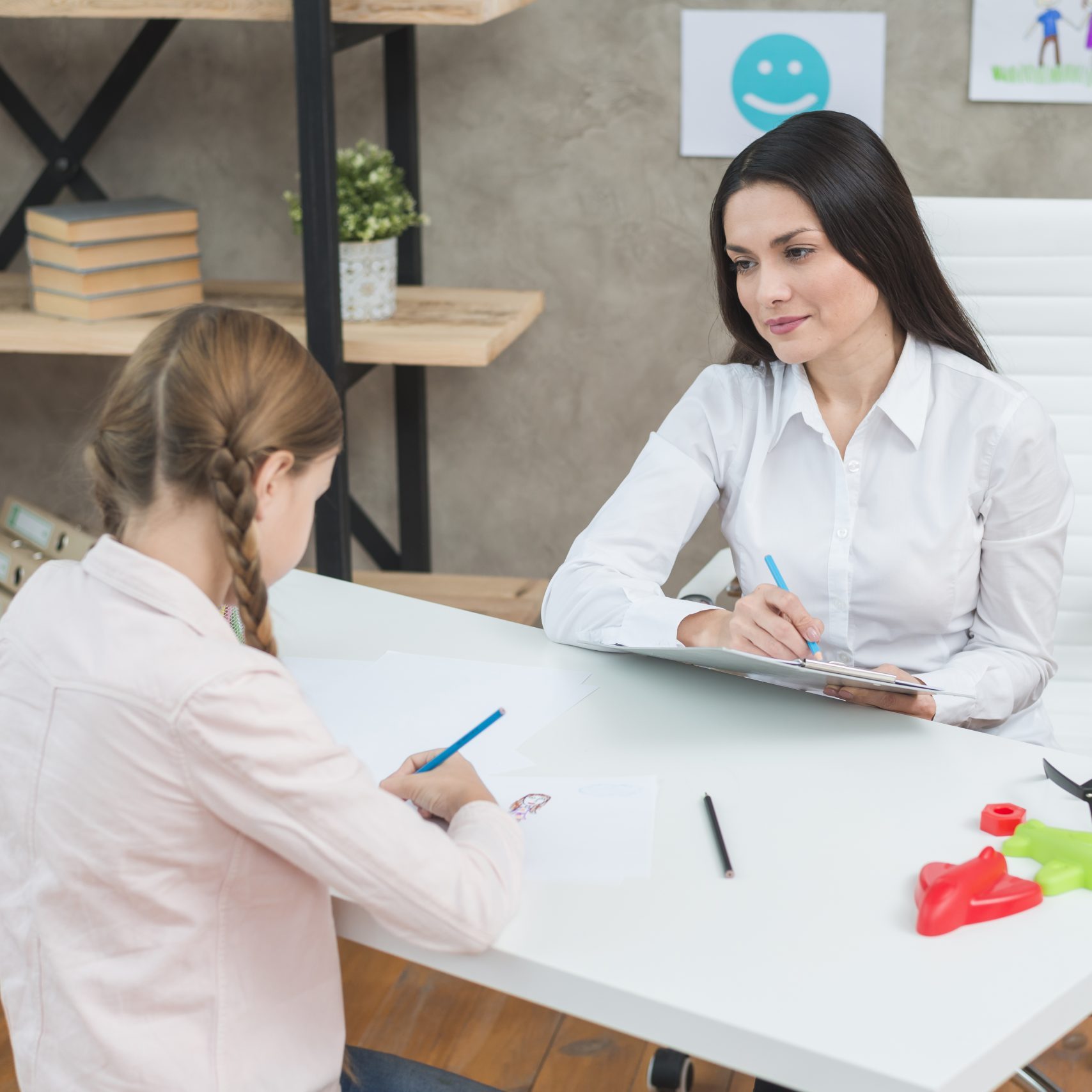 smiling-female-psychologist-observing-the-girl-during-the-therapy-session